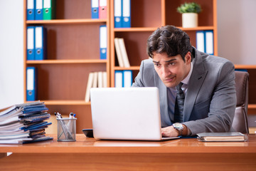 Young handsome businessman unhappy with excessive work 