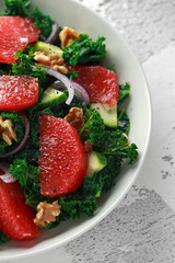 Healthy vegan, vegetarian Grapefruit kale salad with walnuts, red onion and cucumber