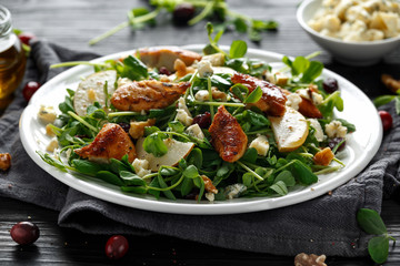 Pear, chicken salad with blue cheese, cranberry and walnuts. concept healthy food. black background