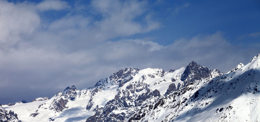 Fototapeta na wymiar View on snowy mountains with glacier and cloudy blue sky