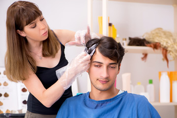 Obraz na płótnie Canvas Young attracrive man visiting female barber 