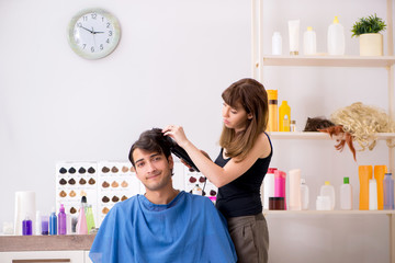 Young attracrive man visiting female barber 