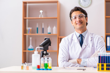 Young handsome biochemist working in the lab 