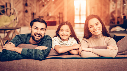 Couple With Daughter Sit On The Couch In Store.