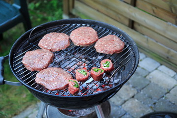 Paddies, Burger, Wurst und Fleischröllchen auf dem Holzkohle Grill 
