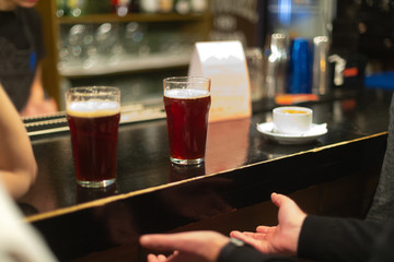 Beer glasses with dark beer are on the bar counter