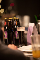 Beer glasses with dark beer are on the bar counter