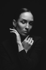 Obraz premium Black and white portrait of attractive brunette sexy girl. Beautiful girl posing. Young woman on black background. Studio shot