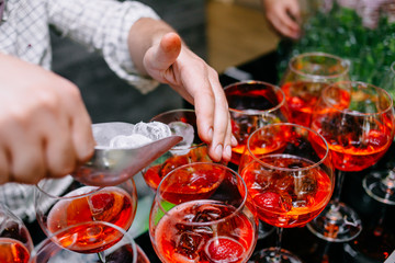 Red cocktail with strawberries. Strawberry daiquiri made with rum,brandy,lime juice, fresh strawberries,grenadine. Refreshing cocktails for a big company. A party. Soft focus.