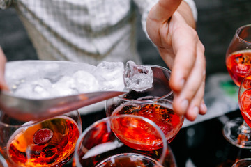 Red cocktail with strawberries. Strawberry daiquiri made with rum,brandy,lime juice, fresh strawberries,grenadine. Refreshing cocktails for a big company. A party. Soft focus.