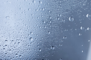 Water drops or droplets on a glass on a rainy day. Close up shot and macro. 