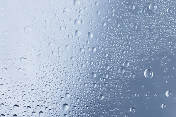 Water drops or droplets on a glass on a rainy day. Close up shot and macro. 
