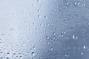 Water drops or droplets on a glass on a rainy day. Close up shot and macro. 
