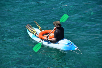 Beach lifeguard man at kayak boat in sea water