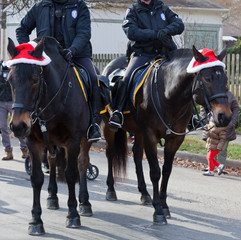 Mounted police horse patrol during holiday parade.