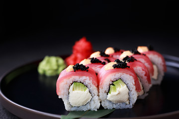 philadelphia sushi roll with avocado and cream cheese, covered with tuna slices and black caviar