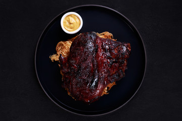 grill bar and pub food, traditional oktoberfest beer snack, german cuisine. roast pork knuckle served with stewed cabbage and mustard sauce