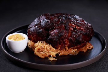 roast pork knuckle served with stewed cabbage and mustard sauce. grill bar and pub food, traditional oktoberfest beer snack, german cuisine