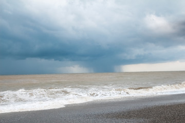 Sea coast during a storm, white foam and waves