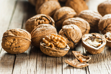 Pile whole big walnut kernel with thin shell on wooden vintage rustic backdrop. healthy food for brain. Fresh walnuts  background concept
