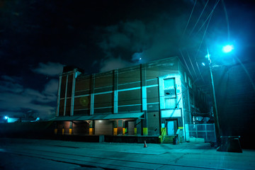 Industrial urban street city night scene with vintage factory warehouses and train tracks