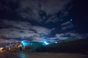 Industrial urban street city night scene with vintage factory warehouses and the moon