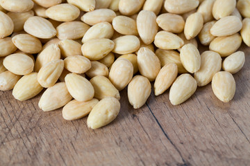 peeled almonds on wooden surface