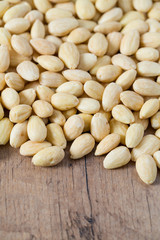 peeled almonds on wooden surface