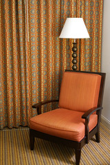 close up on chair, lamp and curtain in hotel room
