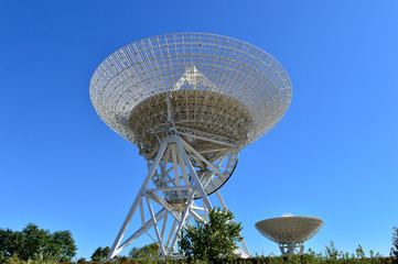 Array of satellite dishes or radio antennas against sky. Space o