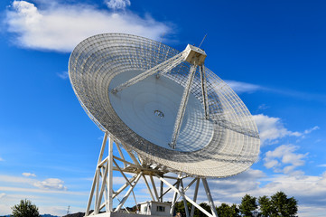 Array of satellite dishes or radio antennas against sky. Space o