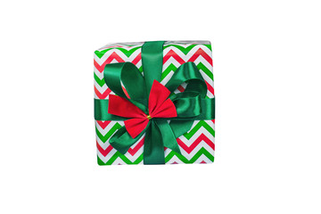 The box is sealed with beautiful paper in green-red-white tones and tied with a green ribbon and a red bow from above on an isolated white background, top view