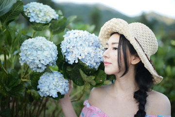 Beautiful girl with a field of hydrangea flowers.