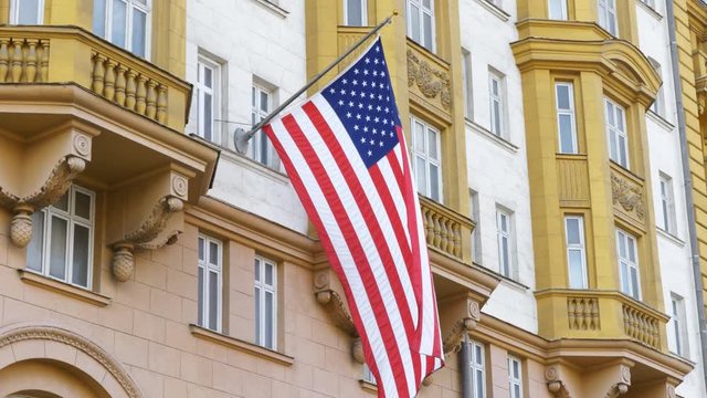 Wrapped around flagpole flag of the USA in Russia Moscow.