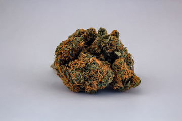 A pile of Cheese OG marijuana buds in the shape of a ball isolated with a white background as a product shot.