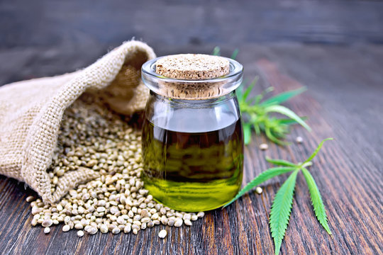 Oil hemp in jar with seed in sack on board