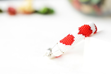 Bead crochet bracelet white color with red hearts print close up