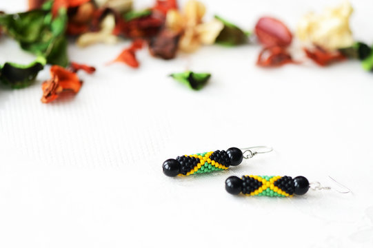 Handmade beaded earrings in style of jamaican flag close up
