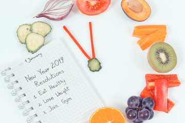 Goals for new year 2019 in notepad and fruits with vegetables in shape of clock