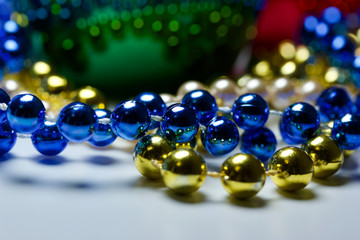 Macro holiday abstract with colorful beads reflecting onto a metallic green container