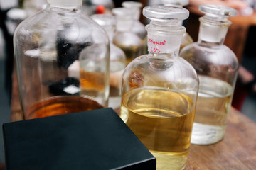 Close up amber color bottles on the shelf in old perfume laboratory. Flasks and examples of odor in the perfume shop.