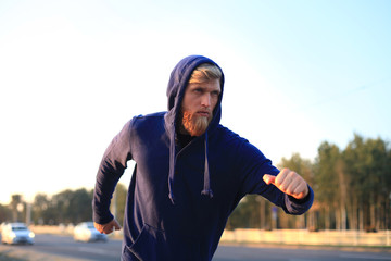 Fototapeta premium Fit athlete. Handsome adult man running outdoors to stay healthy, at sunset or sunrise. Runner.