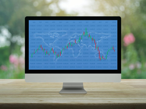 Trading graph of stock market with world map and graph on computer monitor screen on wooden table over blur flower, Business investment online concept, Elements of this image furnished by NASA
