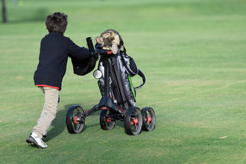 junior golfers pushing carts