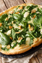 Tasty diet pizza with spinach, garlic and cheese close-up. vertical