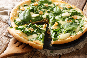 Healthy white pizza with spinach, garlic and ricotta cheese and mozzarella close-up. horizontal