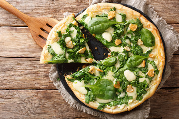 Crispy Italian diet white pizza with spinach, garlic and cheese close-up on the table. horizontal...