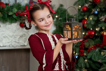 Beautiful girl with lantern in retro dress near classic christmas tree at home. Series.
