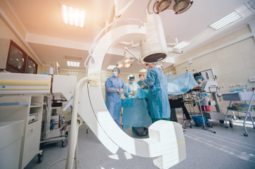 Process of trauma surgery operation. Group of surgeons in operating room with surgery x-ray...