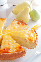 Pie from curd pastry with pear and sour cream, cut into pieces, selective focus